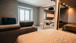 Une chambre d’hôtel moderne équipée d’un grand lit, d’une télévision, d’un bureau et d’une chaise.