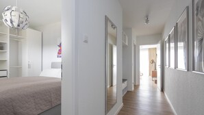 A modern bedroom with a bed, a wardrobe, and a mirror. - Park - Apartment 12 im Marinapark Scharmützelsee, Sauna, Whirlpool, E - Kamin, 4 Pers., 80 m² (Wendisch Rietz Siedlung)