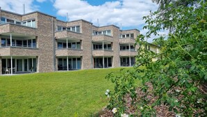 A modern multi-story building with balconies and large windows. - Park - Apartment 12 im Marinapark Scharmützelsee, Sauna, Whirlpool, E - Kamin, 4 Pers., 80 m² (Wendisch Rietz Siedlung)