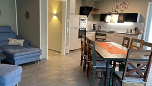 A modern apartment with a living area, dining space, and kitchenette. - Park - Apartment 01 im Marinapark Scharmützelsee, Sauna, Whirlpool, 6 Pers., 98 m² (Wendisch Rietz Siedlung)