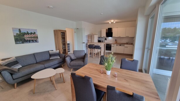 Un appartement moderne comprenant un salon, un coin repas et une cuisine.