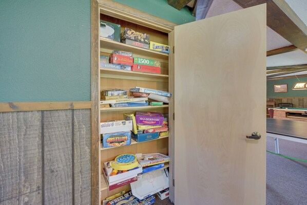 A wooden shelf unit filled with board games.