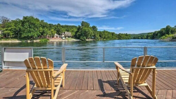 A wooden deck with two Adirondack chairs overlooking a river. - Jack's Cabin-Fall Creek Resort Amenities (Branson)