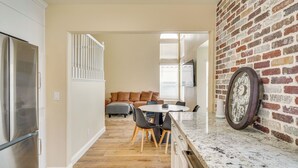 A kitchen with a marble countertop, a refrigerator, and a dining area with a table and chairs. - Luxe 3BR Executive Home w/ Pool, Office & Patio (Las Vegas)