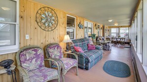 Un intérieur chaleureux avec des meubles en osier, un élément décoratif mural et un coin repas comprenant des chaises et une table.