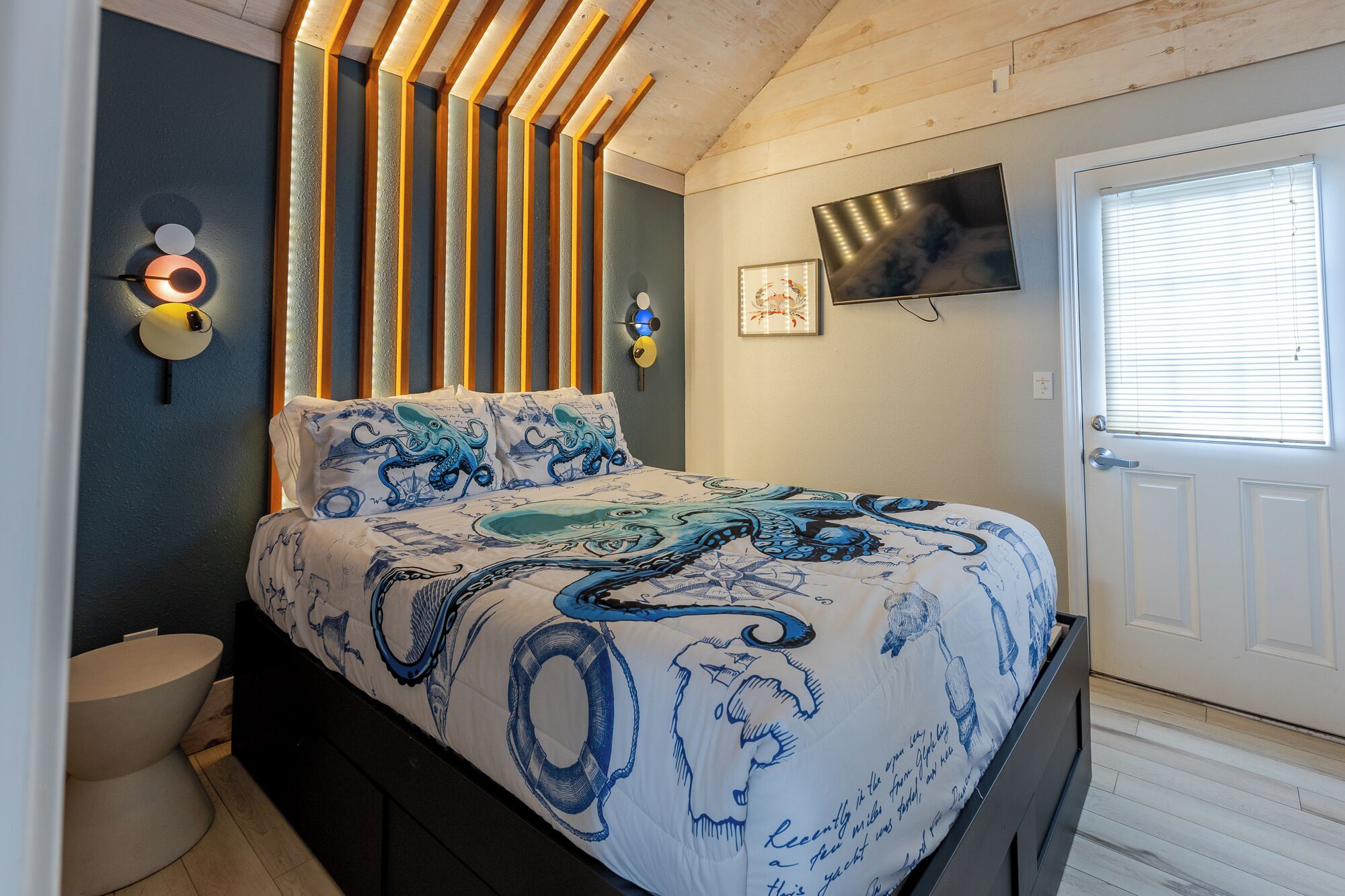 Ein Schlafzimmer mit Bett, Fernseher, Tür und Fenster.
