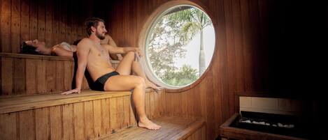 Una sauna con bancos de madera y un ventanal circular.
