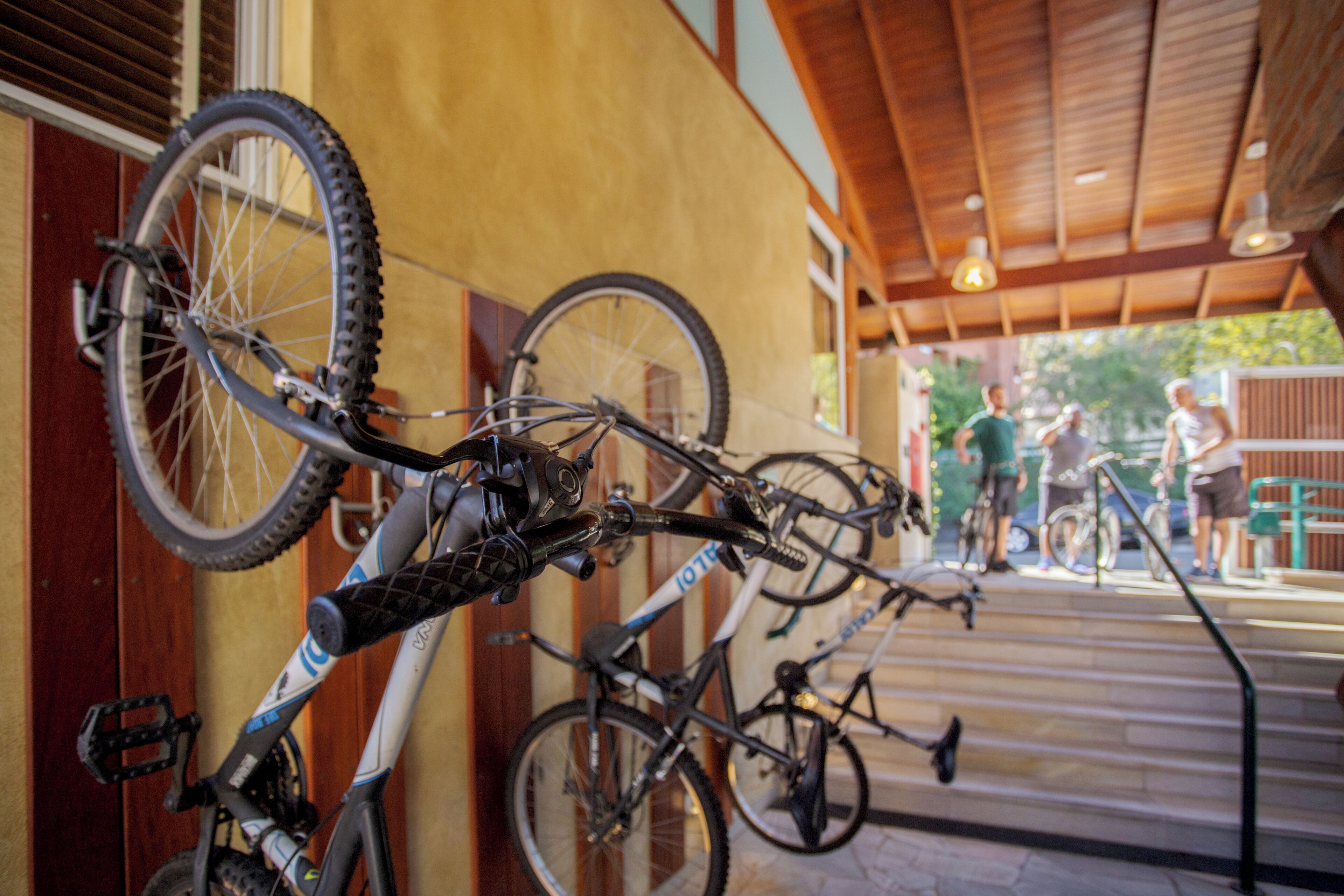 Un espace extérieur abrité où des vélos sont rangés contre un mur.