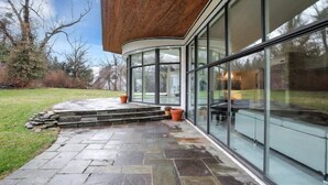 Un bâtiment moderne doté de grandes fenêtres en verre et d’une entrée pavée de pierres.