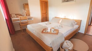 Un dormitorio ordenado con una cama, un escritorio y una pequeña cesta.