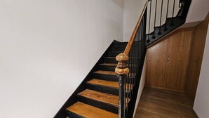 Eine Treppe mit Holzstufen und einem schwarzen Geländer.
