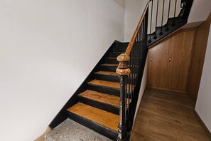 Un escalier avec des marches en bois et une rampe noire.