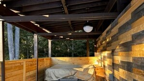 A wooden deck with a bed and a bench. - Elemental Resort (Gwinn)