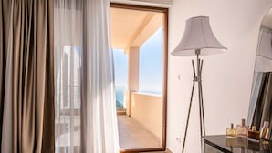 A room with a view to a balcony, a floor lamp, and a table with perfume bottles. - Villa Beta with Pool (Budva)