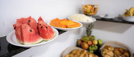 Una mesa de buffet con diversas frutas y pasteles.