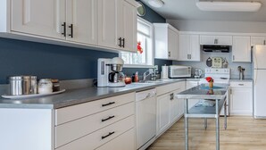 A modern kitchen with white cabinets, a stainless steel coffee maker, a microwave, and a refrigerator. - Blue Octopus #6 Beach Access. Ground Level. (Rockaway Beach)