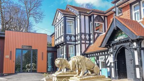 A building with a reception area, a lion statue, and a sign indicating holiday bookings. - Woodlands Retreat (Ruthin)