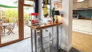 Une cuisine équipée d’un four à micro-ondes, une petite table avec des chaises, un ananas décoratif et un panneau accroché au mur.