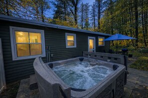 Un jacuzzi situé devant un immeuble avec des fenêtres, entouré d’arbres.