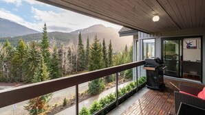 En balkon med udsigt over skov og bjerge.