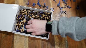 Un groupe de personnes est en train d’assembler des pièces de puzzle en bois sur une table en bois.
