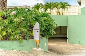 A parking sign with 'Estacionamento' and an arrow pointing left, surrounded by lush green foliage. - Île de Pipa - Ma Plage Hotel (Tibau do Sul)