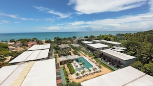 Un resort con varias edificaciones, una piscina y vista al océano.