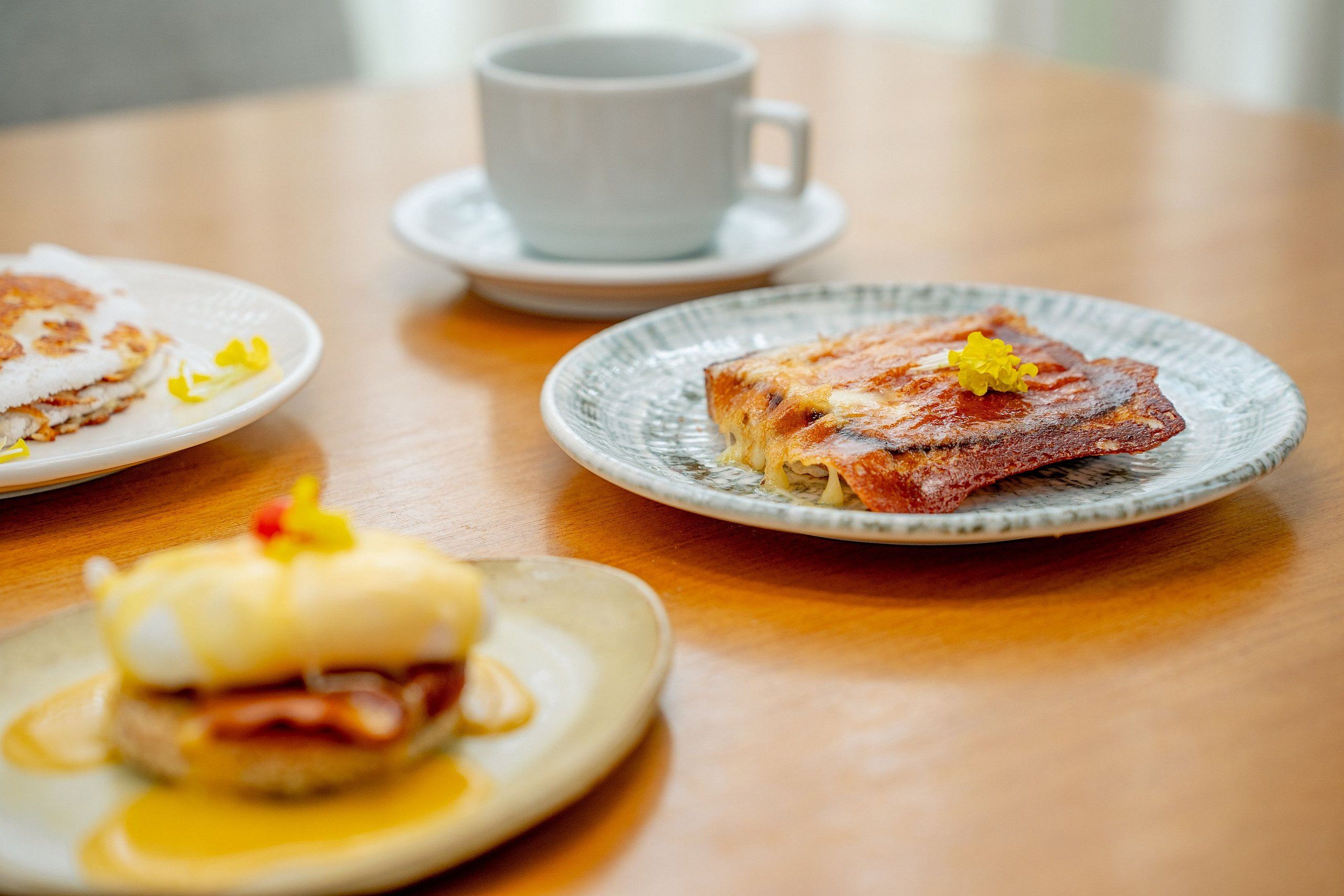 A table with plates of food and a cup of coffee.