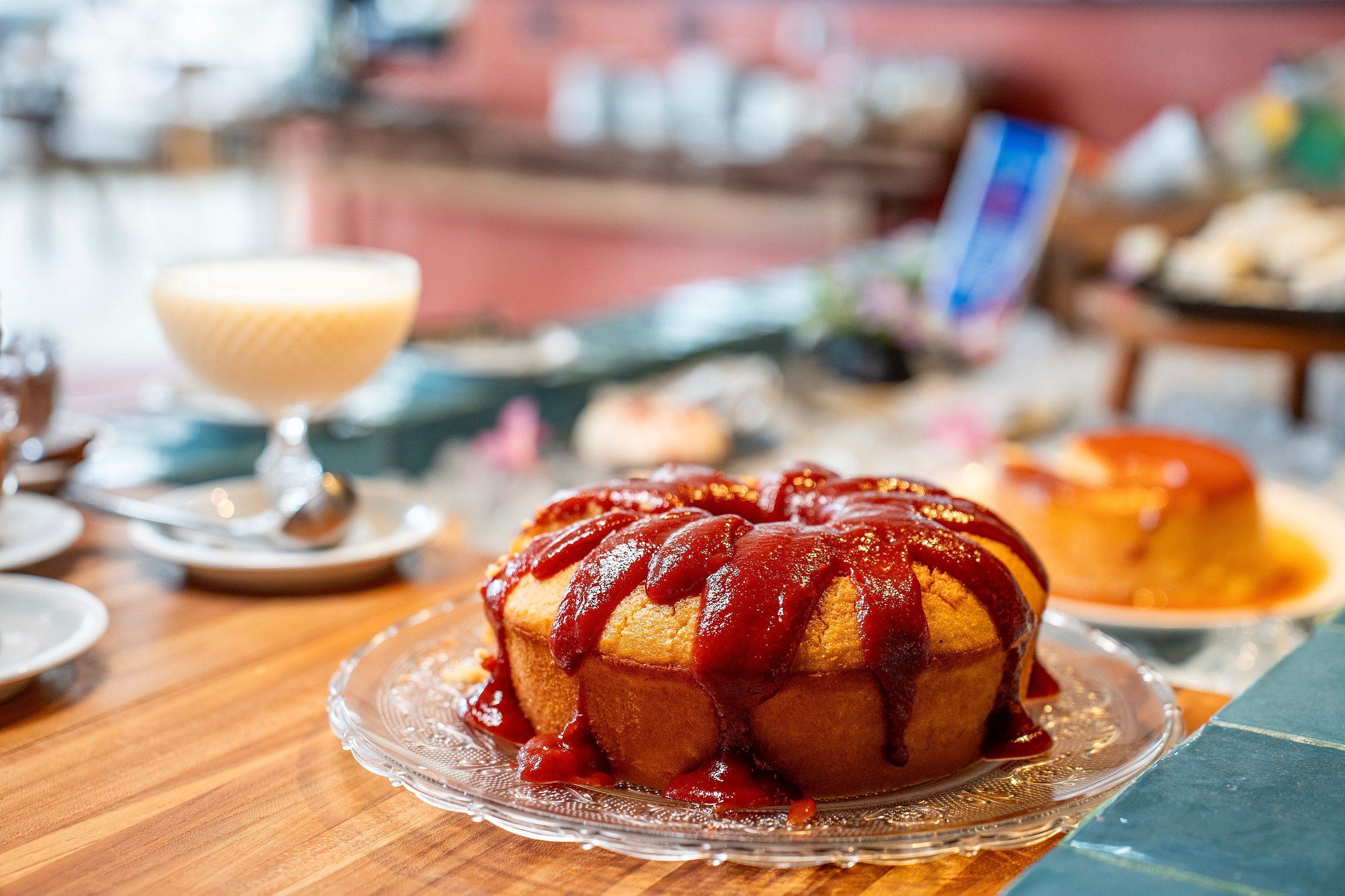 Un postre sobre un plato de vidrio, un vaso de postre y un pastel sobre un plato.
