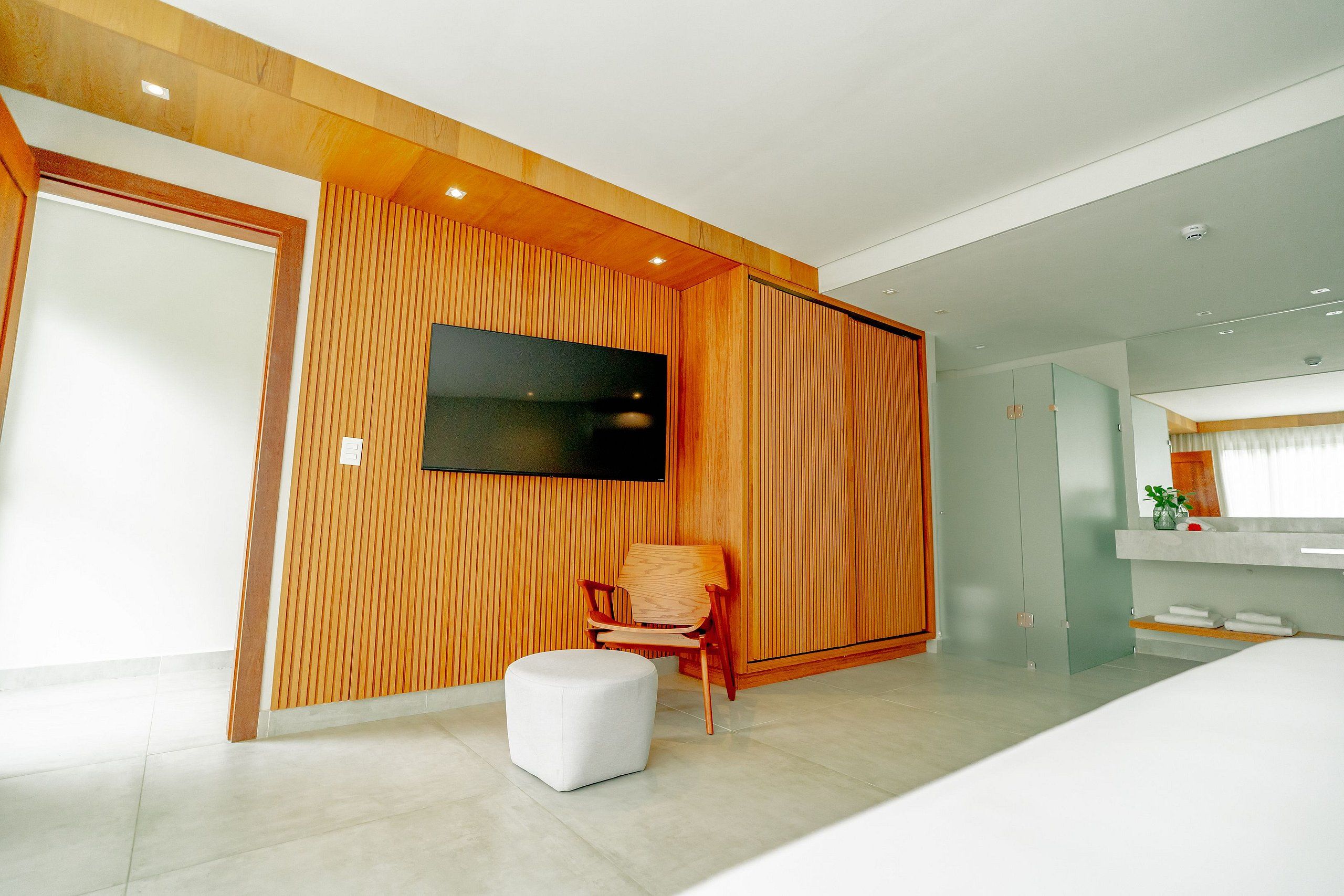 A modern bathroom with a large mirror, a sink, and a toilet.