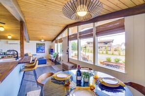 A dining area with a wooden ceiling, large windows, and a view of the outside. - Whidbey Island Oasis: Walk to Beach, Hot Tub, View (Greenbank)