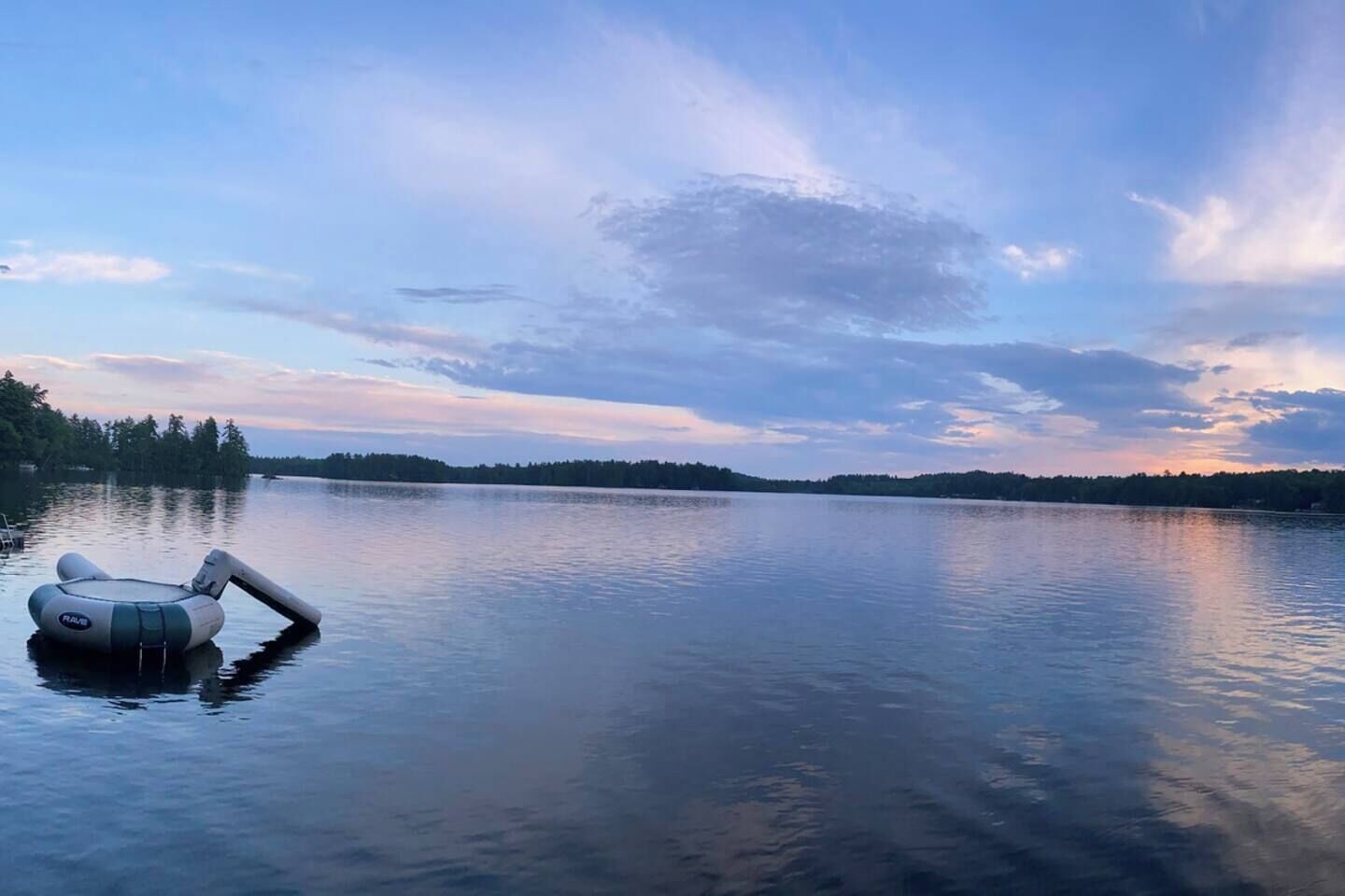 Ein ruhiger See mit einer aufblasbaren Luftmatratze, die auf dem Wasser treibt.