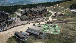 A lodge with multiple buildings, a parking area, and a golf course.