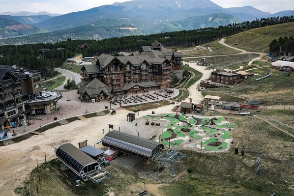 A lodge with multiple buildings, a parking area, and a golf course.