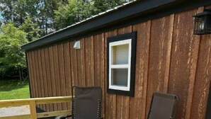 A wooden deck with two metal chairs and a small window. - Between the Waters Rustic Retreat (Hilham)