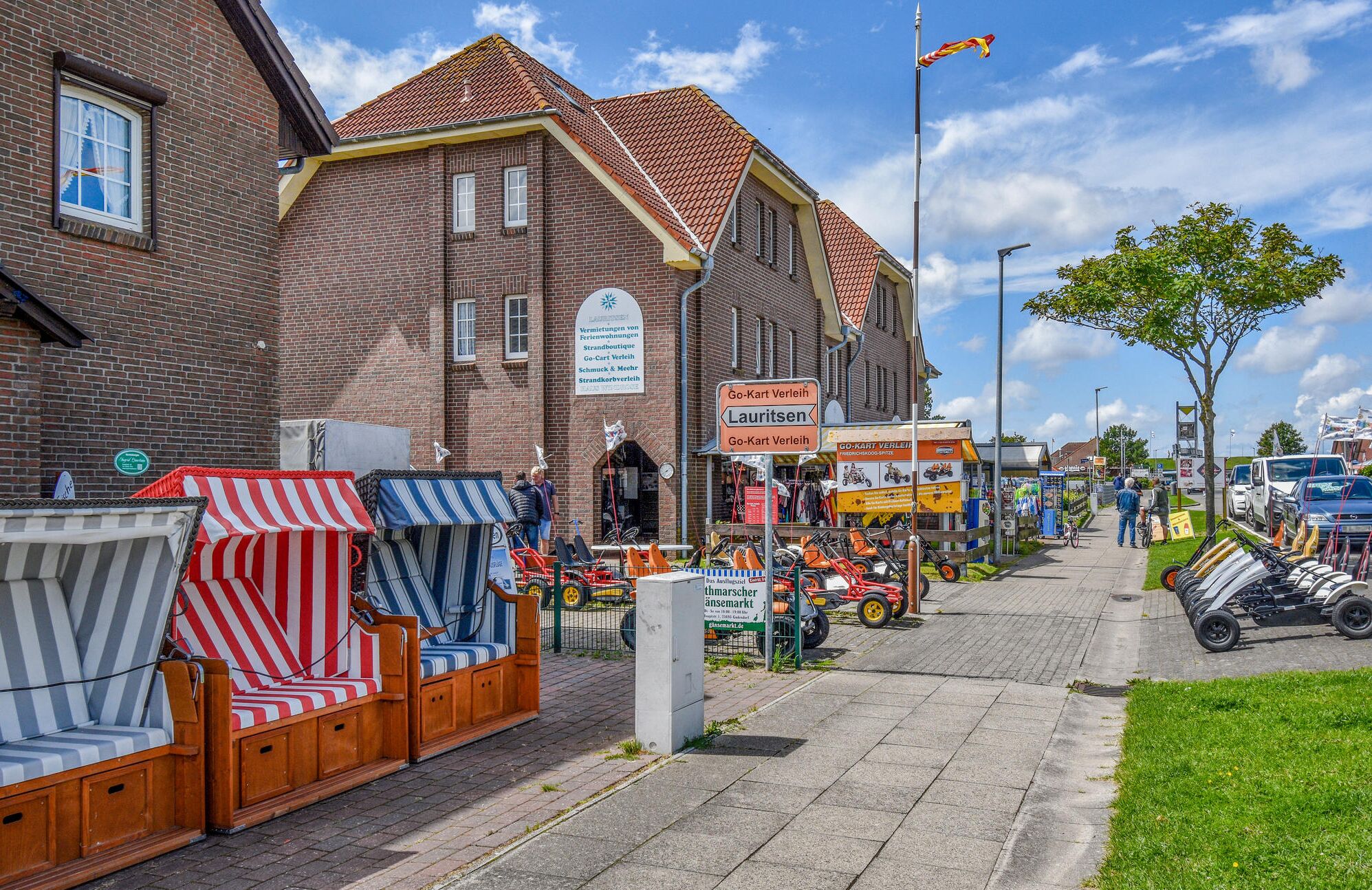 Een straat met een bakstenen gebouw, een gocartbaan en een klein marktgedeelte.