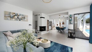Una sala de estar moderna con chimenea, un comedor y vista a una piscina.