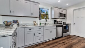 Una cocina moderna con gabinetes grises, un microondas y un lavavajillas.