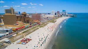 Un paisaje urbano costero con una playa extensa, edificios altos y un cielo azul despejado.