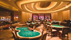 Un casino con múltiples mesas de blackjack y máquinas tragamonedas.