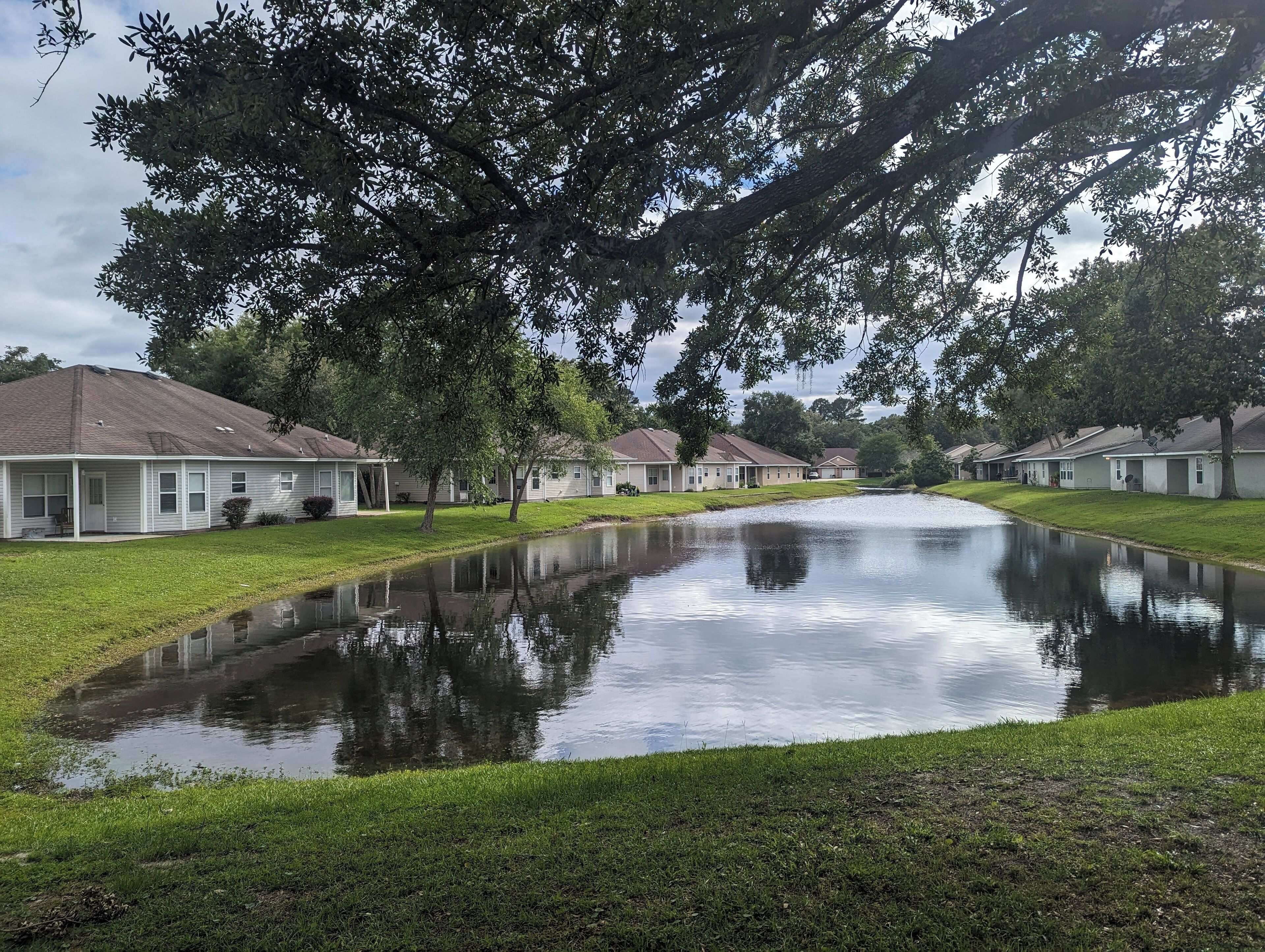 Un quartier résidentiel où les maisons sont alignées le long d’un cours d’eau étroit.