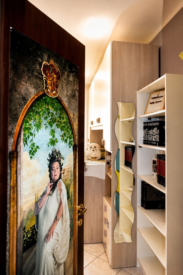A room with a wooden door, a bookshelf, and a painting.