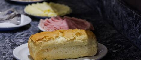 Un bufé con diferentes opciones de comida, incluyendo pasteles, sándwiches y postres.