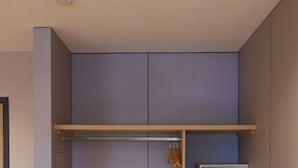 A modern room with a built-in wardrobe, a microwave, and a small refrigerator. - Fuente Mayor Hotel Terminal (Mendoza)
