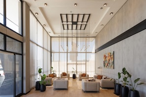 Un vestíbulo amplio con ventanas grandes, muebles modernos y un diseño de techo único.