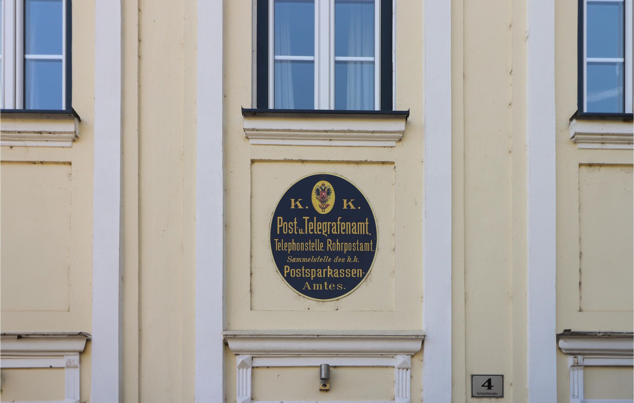 Fachada de prédio com placa indicando um escritório de serviços postais.