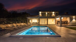 A modern house with a swimming pool, outdoor seating, and a well-lit patio area. - Luxurious home in Labin with private swimming pool, can be inside or outside (Labin)