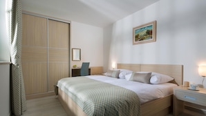 Una camera d'albergo con un letto, comodini, un armadio e un quadro appeso al muro.