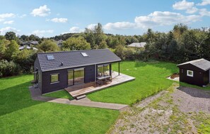 A modern house with a large deck, a covered patio, and a small adjacent shed. - Nice home in Grenaa with WiFi (Grenaa)