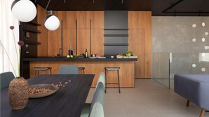 Una cocina moderna con armarios de madera, una isla central y taburetes de bar.